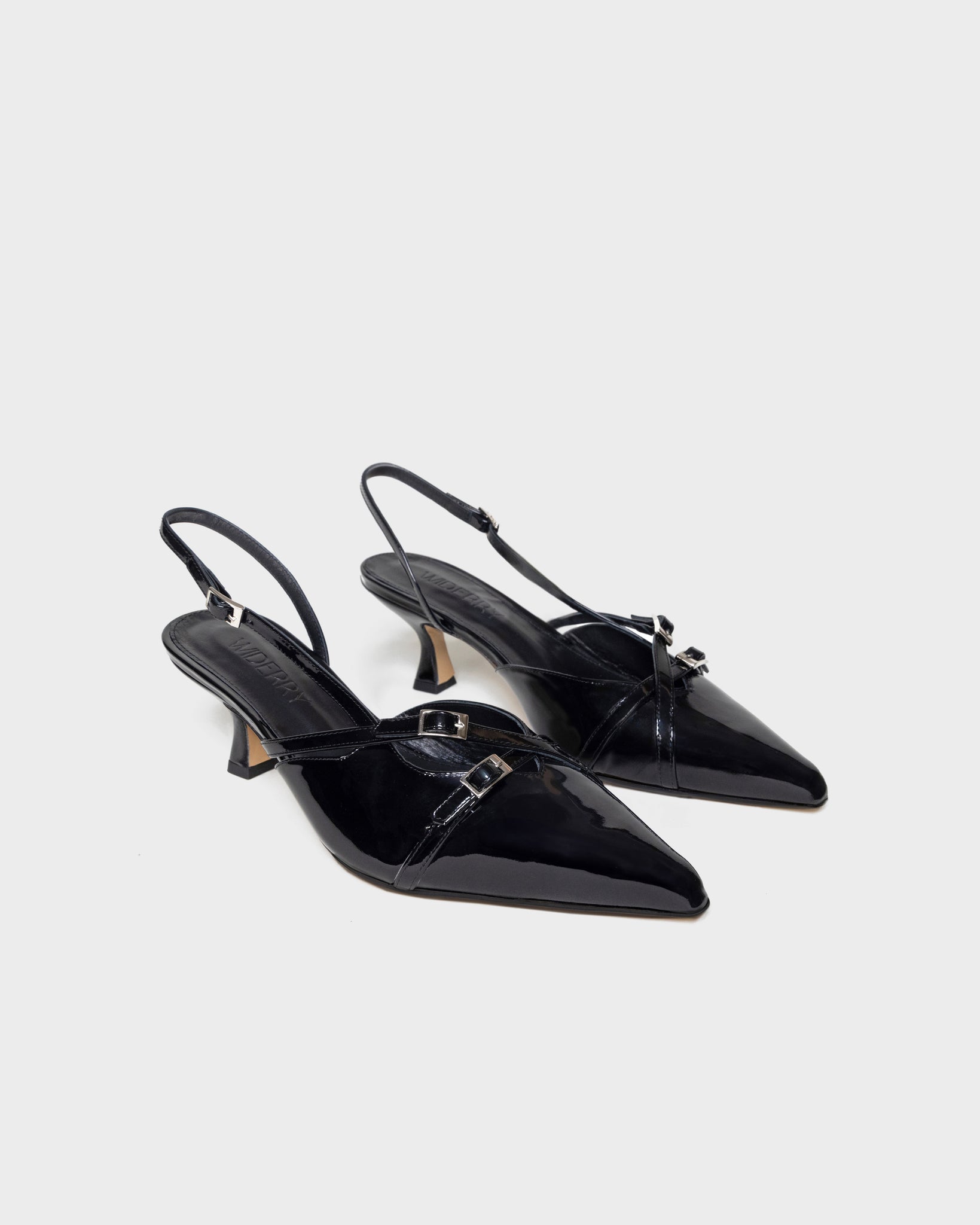 Angled view of black wide fit kitten heels with patent leather finish, stylish and comfortable women's shoes